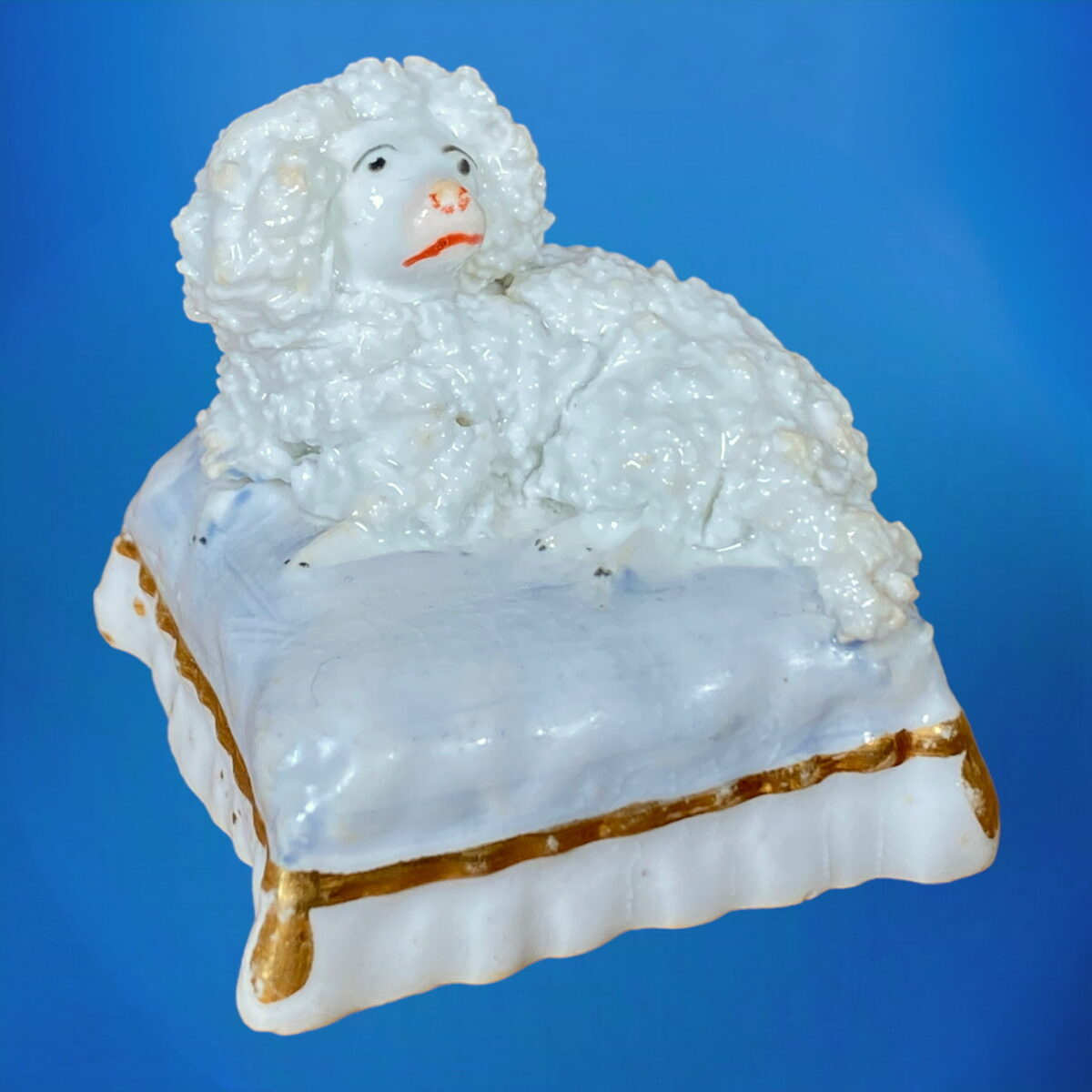 Staffordshire Porcelain Small Poodle on Cushion.