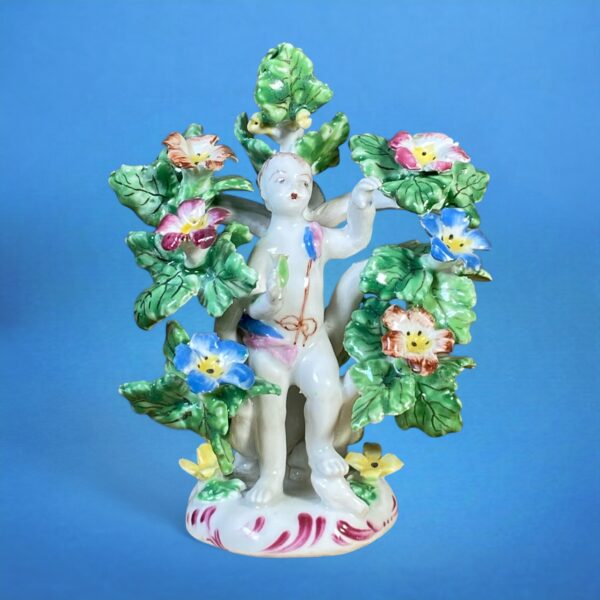 C18th Bow Porcelain Figure of a Putto in a Floral Arbour