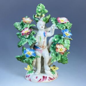 C18th Bow Porcelain Figure of a Putto in a Floral Arbour
