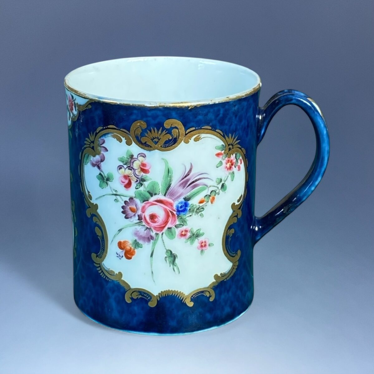 1st Period Worcester Porcelain Scale Blue Mug with Floral Panels.