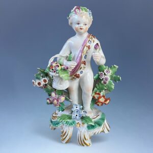 C18th BOW Porcelain - Small Figure of a Putto With Basket of Fruit.