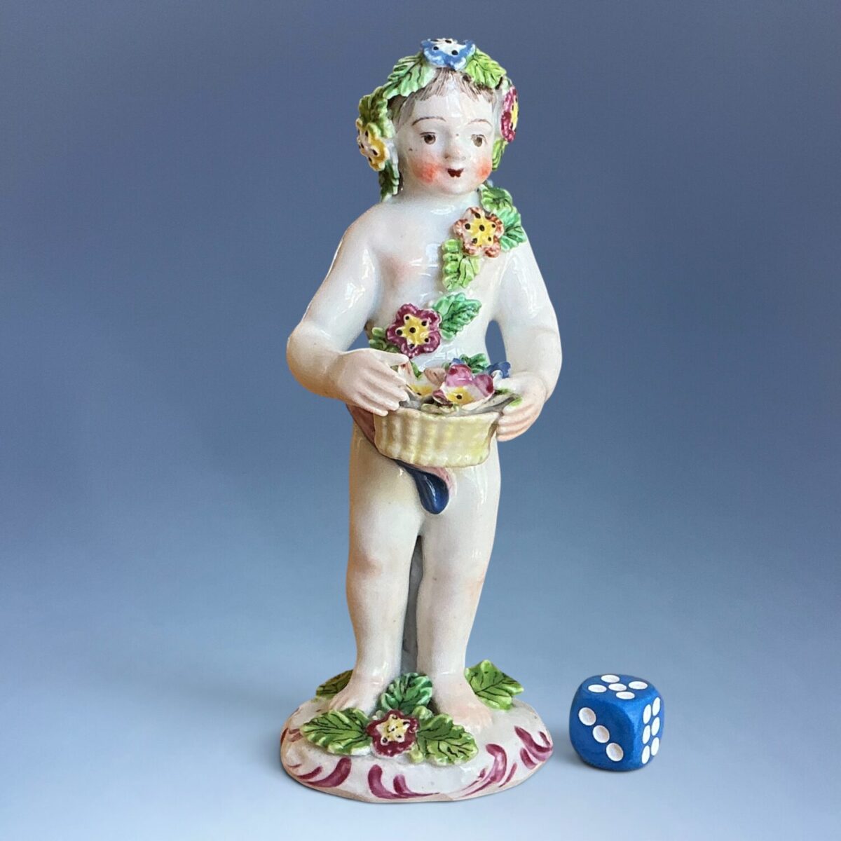 C18th Bow Porcelain Figure of a Putto Holding a Basket of Flowers.